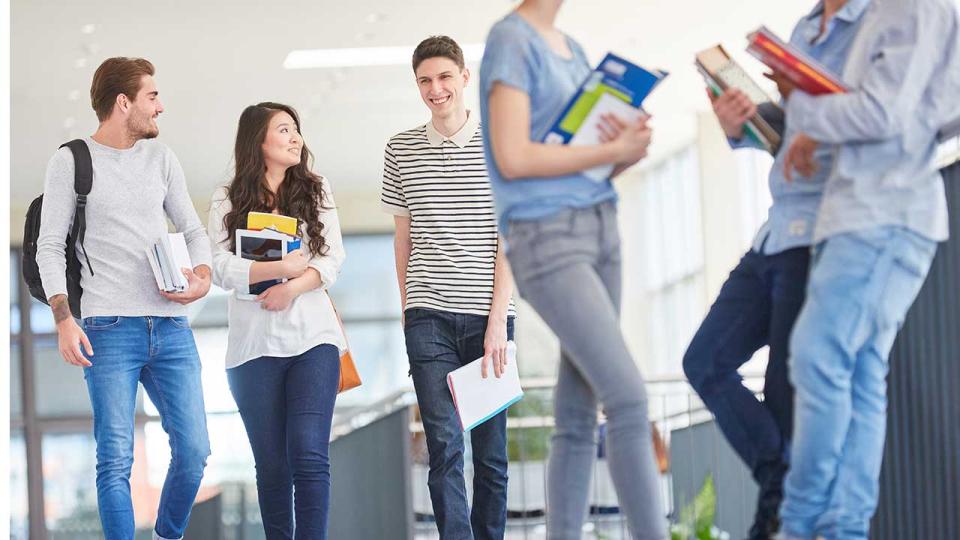 Schülerinnen und 'Schüler unterhalten sich während einer Pause